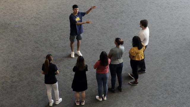 A 赌钱app可以微信提现 guide gives a tour to a group of prospective students